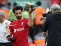 Liverpool's Mohamed Salah holding the Premier League Playmaker and Golden Boot winner trophies after the match on May 22, 2022
