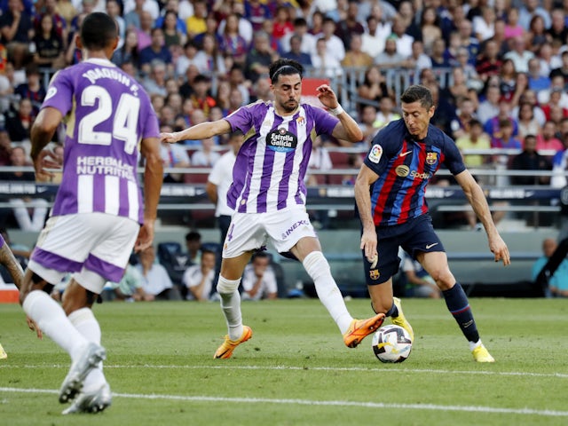 Barcelona's Robert Lewandowski in action with Real Valladolid's Kike Perez on August 28, 2022