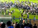 Fans invade the soccer field after a match between Arema FC and Persebaya Surabaya at Kanjuruhan Stadium, Malang, Indonesia Oct 2, 2022