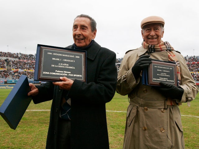 The last two surviving members of Uruguay's 1950 world champion soccer team, Alcides Giggia (L) and Matias Gonzalez, hold commemorative plaques they received from the Uruguayan Soccer Association in 2009