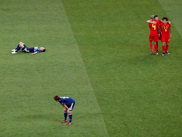 Belgium's Vincent Kompany, Axel Witsel and Thomas Meunier celebrate after the match as Japan's Gen Shoji and Yuya Osako look dejected at the 2018 World Cup