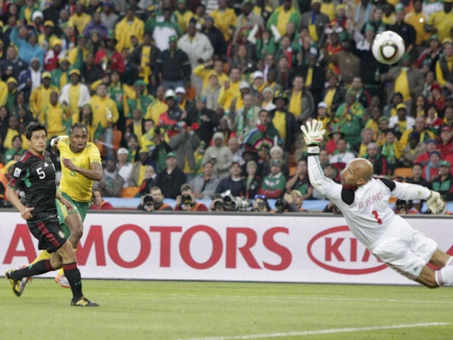 Южноафриканец Сифиве Тшабалала забивает первый гол в ворота голкипера сборной Мексики Оскара Переса во время первого матча ЧМ-2010 в Йоханнесбурге, 11 июня 2010 года.