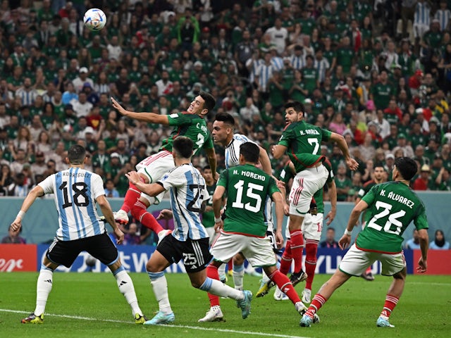 Argentina's Lautaro Martinez battles Mexico's Cesar Montes for the ball at the World Cup on November 26, 2022