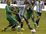 Argentina's Lionel Messi (C) challenges Saudi Arabia's Bader Alnakly (L) for the ball during their friendly soccer match in Riyadh November 14, 2012
