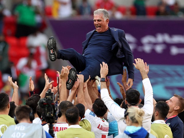 Iran-coach Carlos Queiroz wordt door spelers in de lucht gegooid na hun overwinning op Wales op 25 november 2022