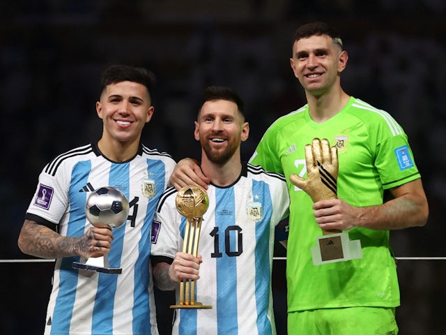 Young Player of the Tournament Enzo Fernandez, Golden Ball winner Lionel Messi and Golden Glove winner Emiliano Martinez pose with their trophies on December 18, 2022