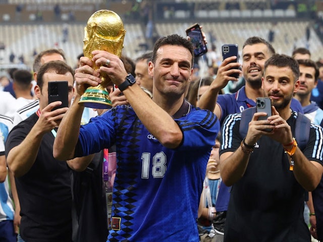 Argentina head coach Lionel Scaloni celebrates winning the World Cup with the trophy on December 18, 2022