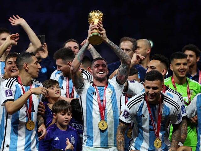 Argentina's Rodrigo De Paul celebrates with the trophy and teammates after winning the World Cup on December 18, 2022