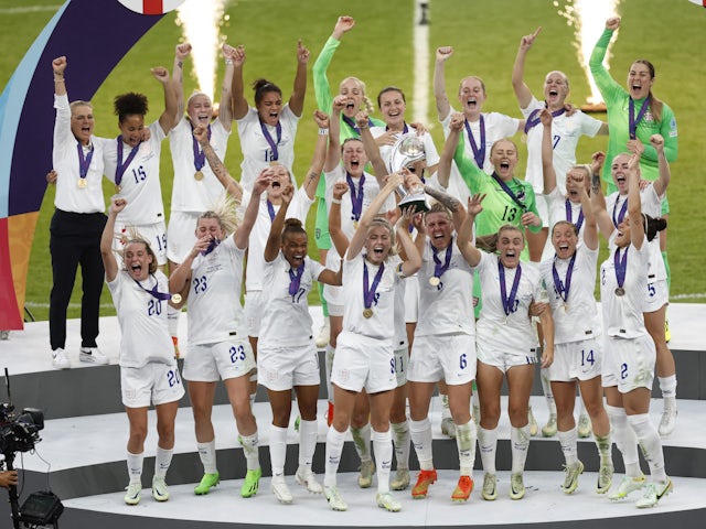 England's Leah Williamson and Millie Bright lift the trophy as they celebrate with teammates after winning Women's Euro 2022 on July 31, 2022