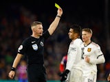 Manchester United's Casemiro is shown a yellow card by referee Robert Jones on January 18, 2023