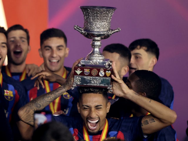 Barcelona's Raphinha celebrates with the trophy after winning the Spanish Super Cup on January 15, 2023