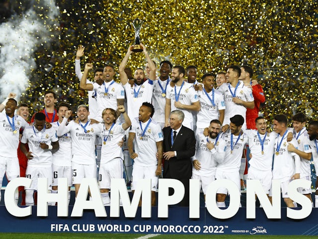 Real Madrid's Karim Benzema lifts the trophy with teammates and coach Carlo Ancelotti after winning the FIFA Club World Cup final on February 11, 2023
