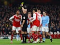 Arsenal's Gabriel Magalhaes is shown a yellow card by referee Anthony Taylor on February 15, 2023