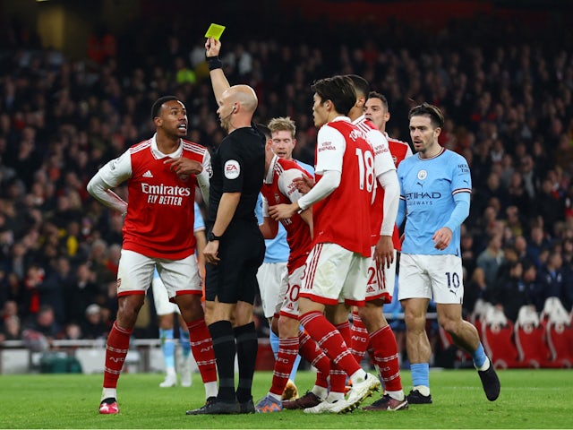 Arsenal's Gabriel Magalhaes is shown a yellow card by referee Anthony Taylor on February 15, 2023