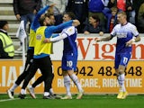 Wigan Athletic's Nathan Broadhead celebrates scoring their first goal with teammates on October 11, 2022