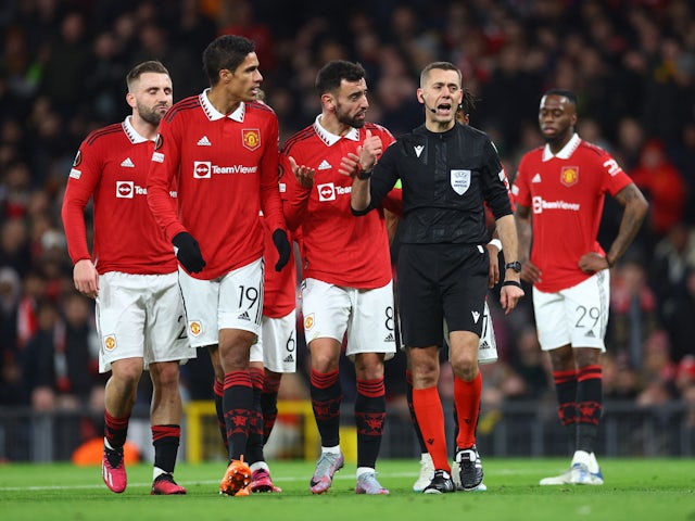 Manchester United players argue with the referee during the clash with Barcelona on February 23, 2023