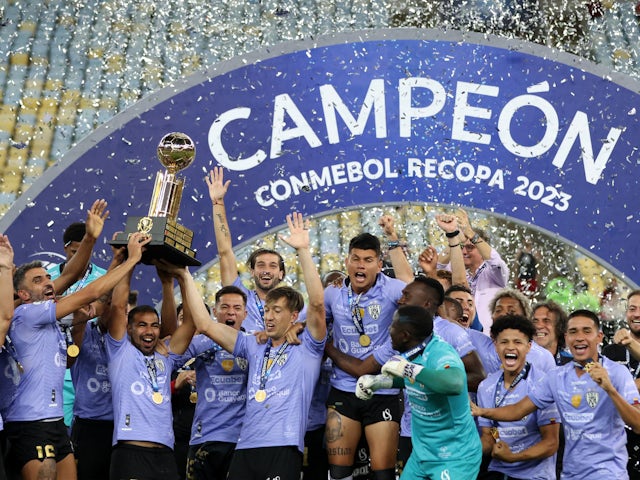 Independiente del Valle's Junior Sornoza celebrates with the trophy and teammates after winning the Recopa Sudamericana on March 1, 2023