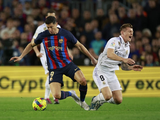 Barcelona's Robert Lewandowski in action with Real Madrid's Toni Kroos on March 19, 2023