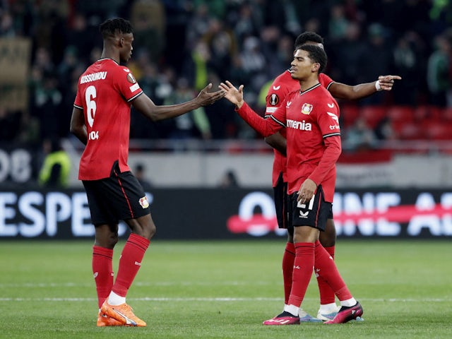 Bayer Leverkusen's Odilon Kossounou shakes hands with Amine Adli after the match on March 16, 2023