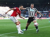 Newcastle United's Dan Burn in action with Manchester United's Diogo Dalot on April 2, 2023
