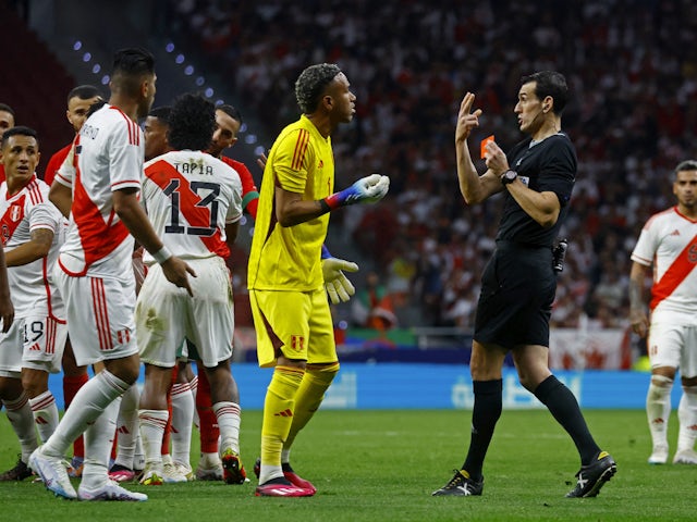 Peru's Carlos Zambrano is shown a red card by referee Jose Luis Munuera Montero as Pedro Gallese remonstrates on March 28, 2023