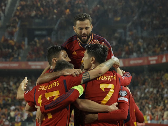 Spain's Dani Olmo celebrates scoring their first goal with teammates on March 25, 2023