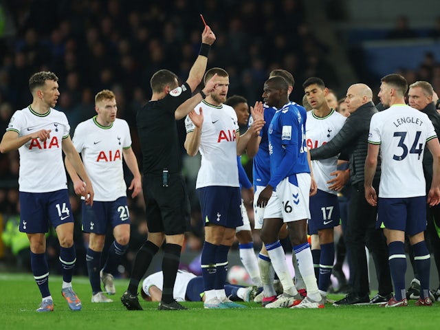 Everton's Abdoulaye Doucoure is shown a red card by referee David Coote as Tottenham Hotspur's Eric Dier looks on on April 3, 2023