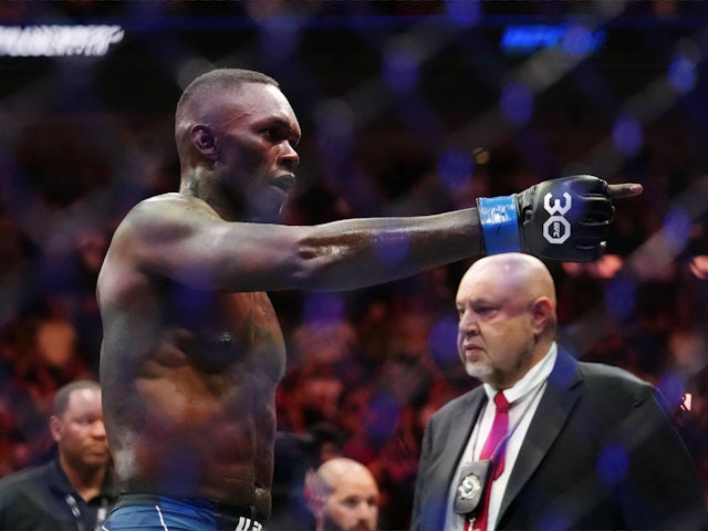 Israel Adesanya (blue gloves) reacts to defeating Alex Pereira (red gloves) during UFC 287 at Miami-Dade Arena on April 9, 2023