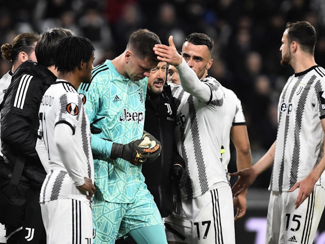 Juventus' Wojciech Szczesny is patted on the head by Filip Kostic as he substituted off after sustaining an injury on April 13, 2023