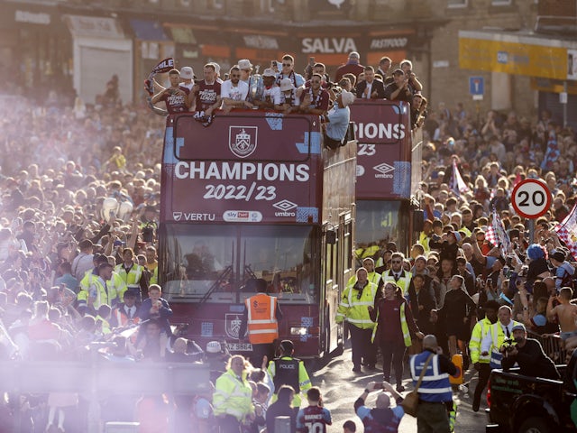 Burnley players hold the trophy on the victory parade bus as they celebrate winning the Championship on May 9, 2023