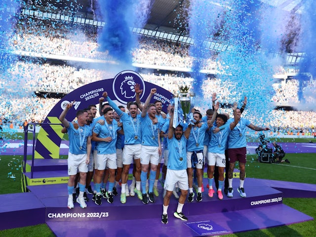 Manchester City's Ilkay Gundogan lifts the trophy as he celebrates with teammates after winning the Premier League on May 21, 2023
