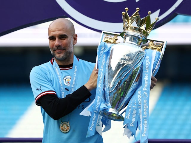 Manchester City manager Pep Guardiola poses with the trophy as he celebrates after winning the Premier League on May 21, 2023