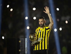 Al-Ittihad new signing Karim Benzema waves to fans as he holds the Ballon d'Or trophy during his presentation on June 7, 2023