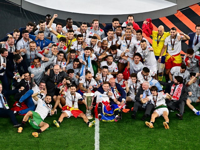 Sevilla players pose for a picture with the trophy after winning the Europa League on May 31, 2023