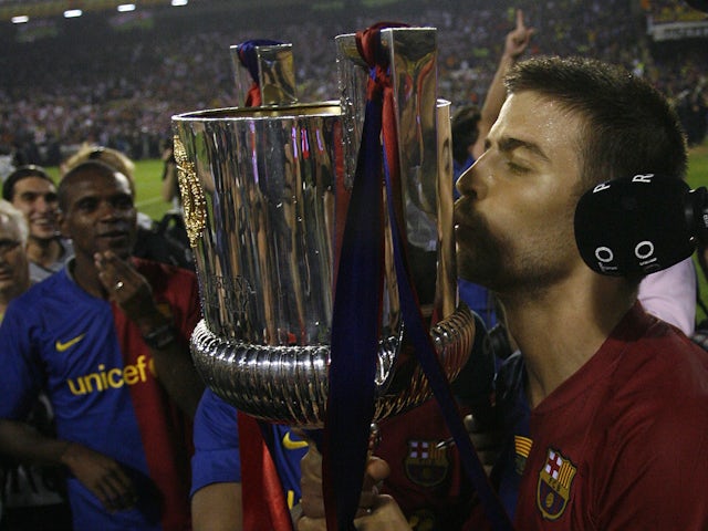 Barcelona's Gerard Pique kisses the trophy after their victory over Athletic Bilbao in their King's Cup final soccer match at the Mestalla stadium in Valencia May 13, 2009