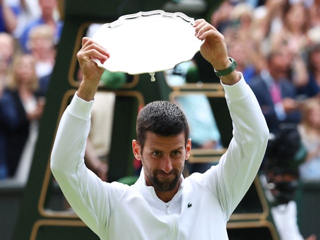 Novak Djokovic holds up the runners-up trophy after losing the Wimbledon final to Carlos Alcaraz on July 16, 2023