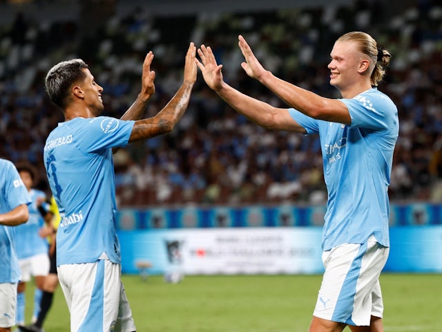 Manchester City's Erling Haaland celebrates scoring their fifth goal with Joao Cancelo on July 23, 2023