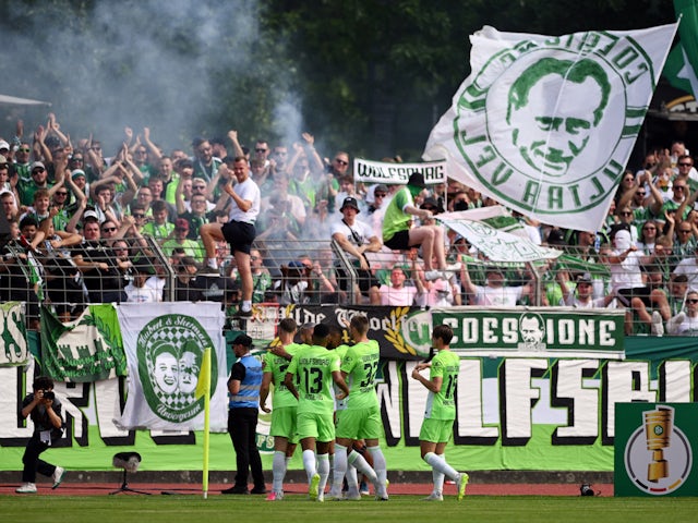 VfL Wolfsburg's Lukas Nmecha celebrates scoring their first goal with teammates on August 13, 2023