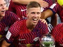 RB Leipzig's Dani Olmo poses with the German Super Cup trophy on August 12, 2023