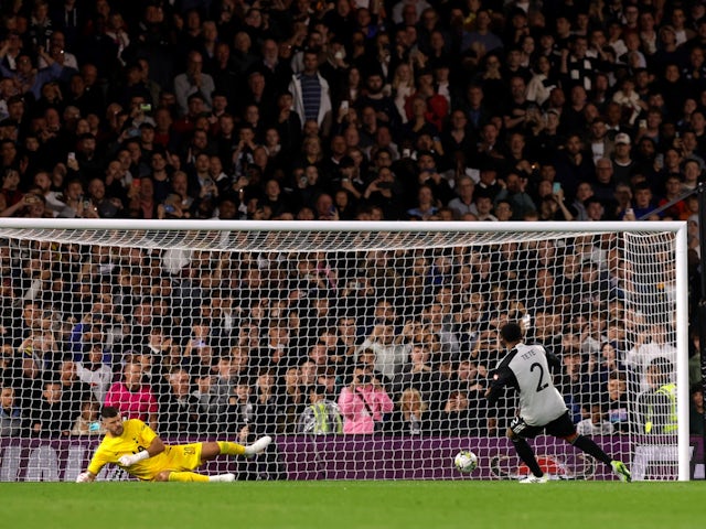 Fulham's Kenny Tete scores the winning penalty past Tottenham Hotspur's Fraser Forster during the shootout on August 29, 2023