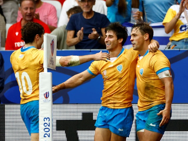 Uruguay's Nicolas Freitas celebrates scoring their second try with teammates Santiago Arata and Felipe Etcheverry on September 20, 2023