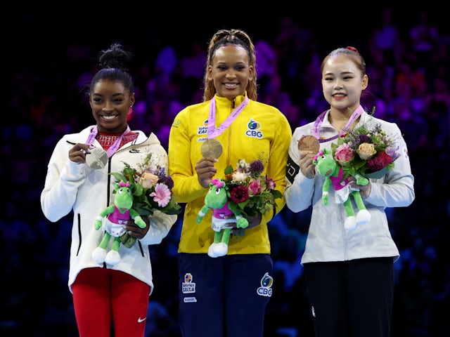 Gold medallist Brazil's Rebeca Andrade celebrates on the podium with her medal after winning the vault exercise at the women's apparatus finals alongside silver medallist Simone Biles of the U.S. and bronze medallist South Korea's Seojeong Ye on October 7
