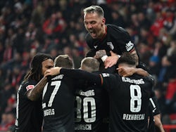 FC Augsburg's Ermedin Demirovic celebrates scoring their first goal with Phillip Tietz and teammates on November 25, 2023