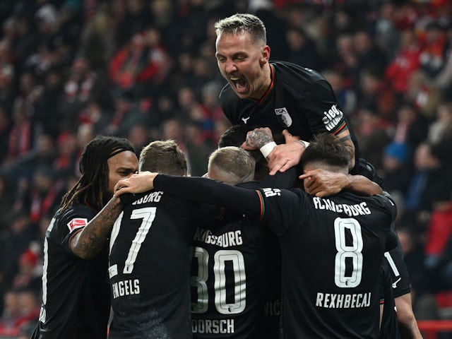 FC Augsburg's Ermedin Demirovic celebrates scoring their first goal with Phillip Tietz and teammates on November 25, 2023