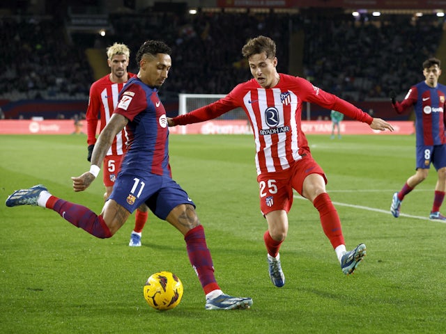 Barcelona's Raphinha in action with Atletico Madrid's Rodrigo Riquelme on December 3, 2023