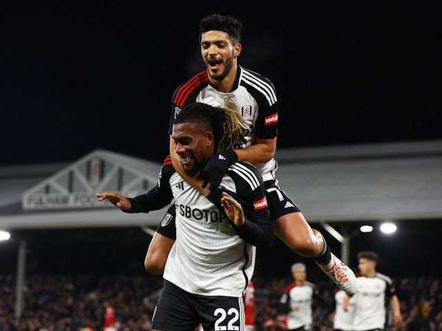 Fulham's Alex Iwobi celebrates scoring their first goal with Raul Jimenez on December 6, 2023