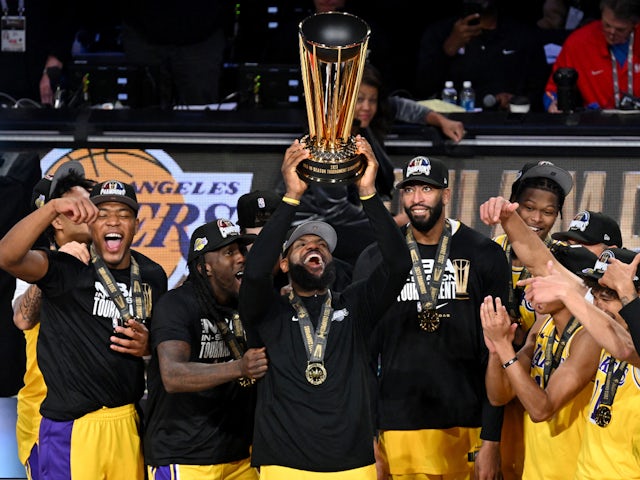 Los Angeles Lakers forward LeBron James (23) hoists the NBA Cup and celebrates with teammates after winning the NBA In-Season Tournament Championship on December 9, 2023