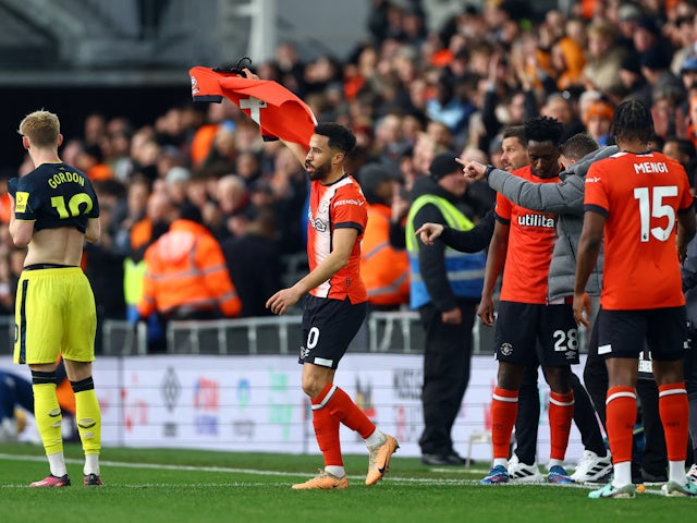 Luton Town's Andros Townsend celebrates scoring their first goal and holds a shirt to support of Luton Town's Tom Lockyer on December 22, 2023