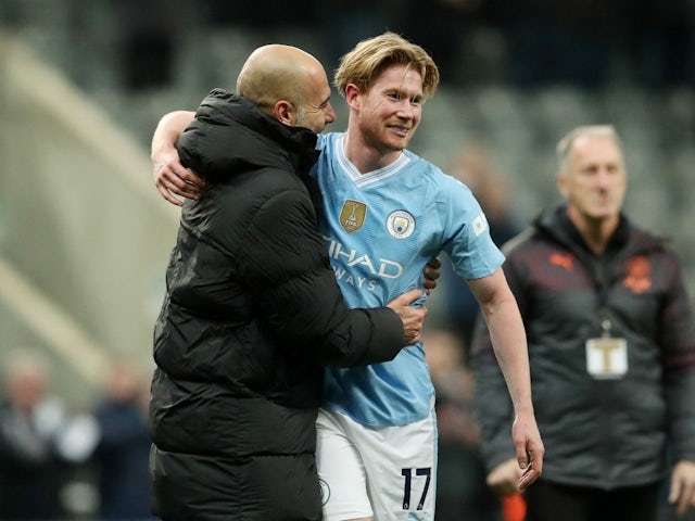 Manchester City's Kevin De Bruyne celebrates with manager Pep Guardiola after the match on January 13, 2024