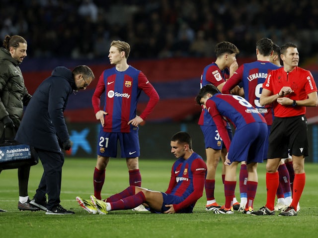 Barcelona's Ferran Torres receives medical attention after sustaining an injury as teammates look on on January 31, 2024